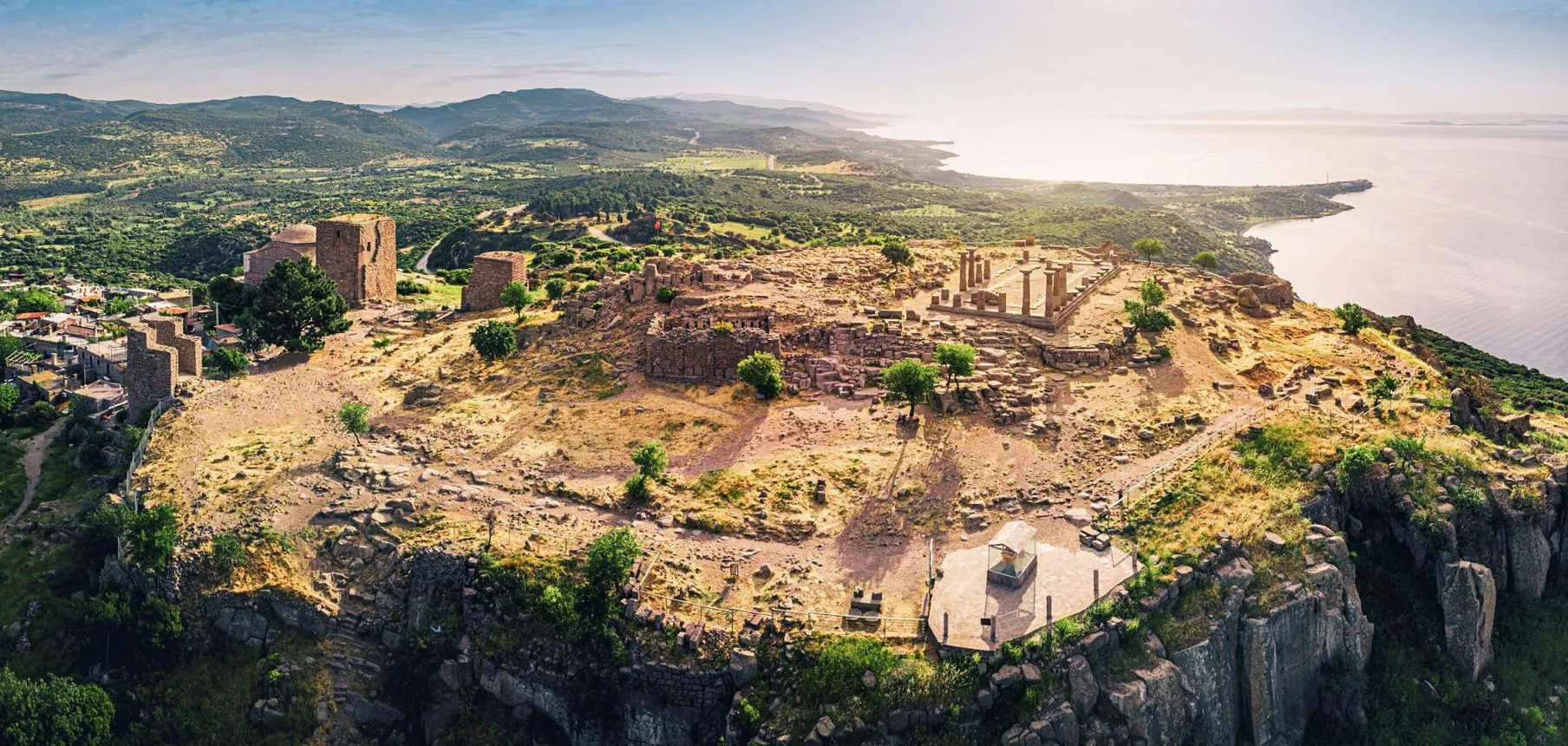 Aerial view of the ruins of Assos on the hilltop above the coast