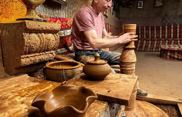 A potter shaping clay at a wheel in an Avanos workshop