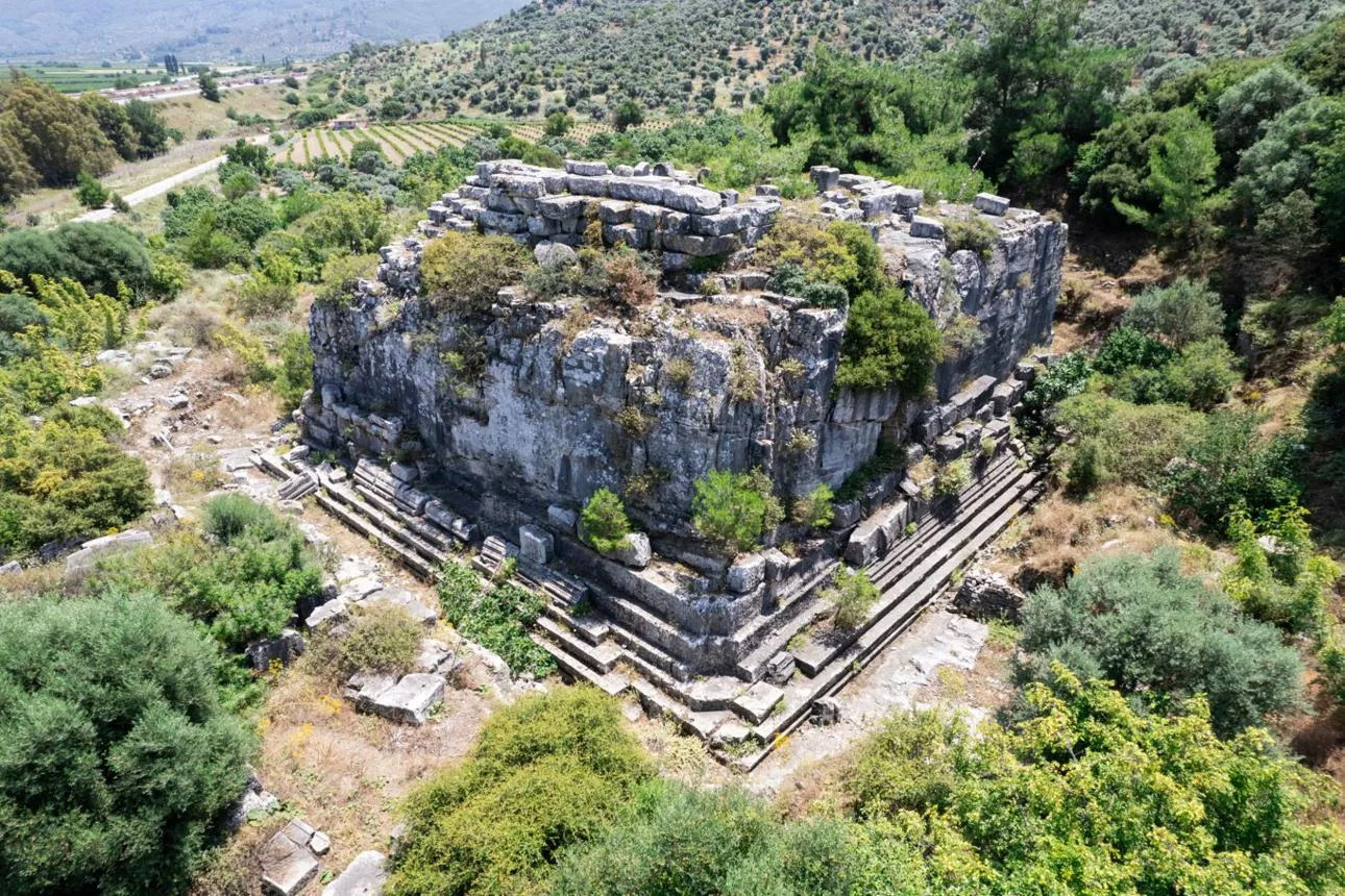 Aerial view of the stone platform of the Belevi Mausoleum among olive trees