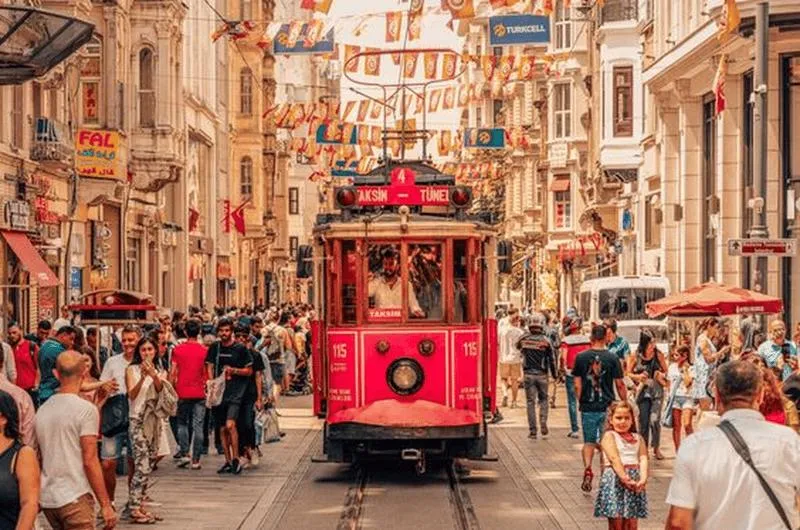 The red nostalgic tram on a crowded İstiklal Avenue
