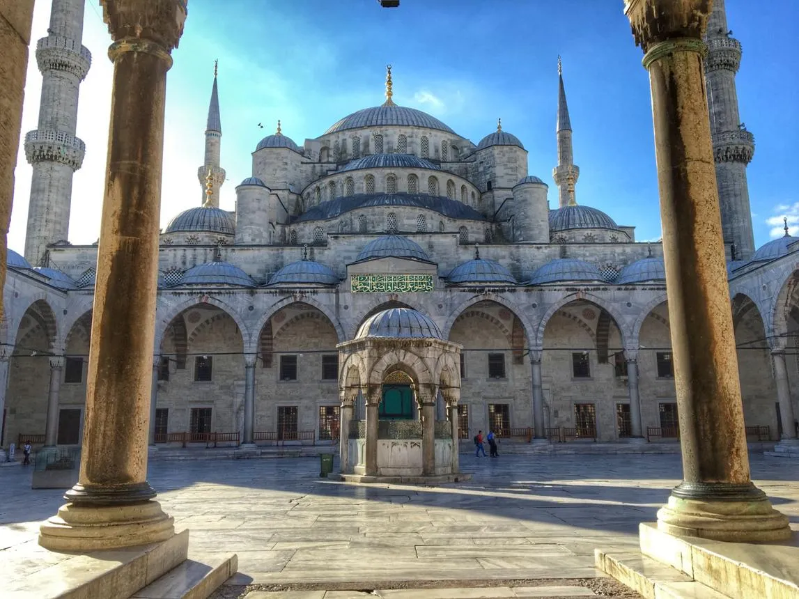 Courtyard and domes of the Blue Mosque framed by marble columns