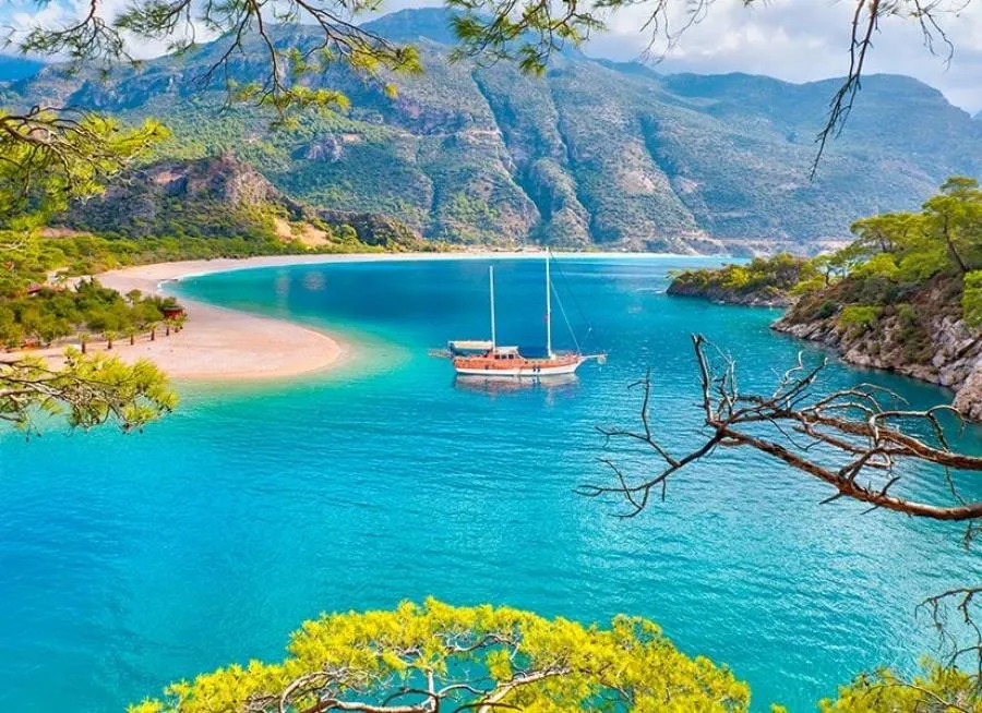 A wooden gulet anchored in the turquoise lagoon of Ölüdeniz