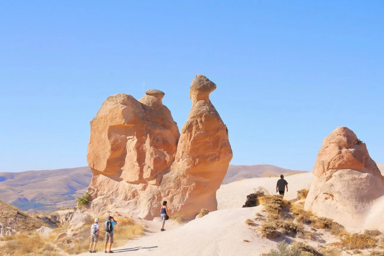 The camel-shaped rock of Devrent Valley with walkers below