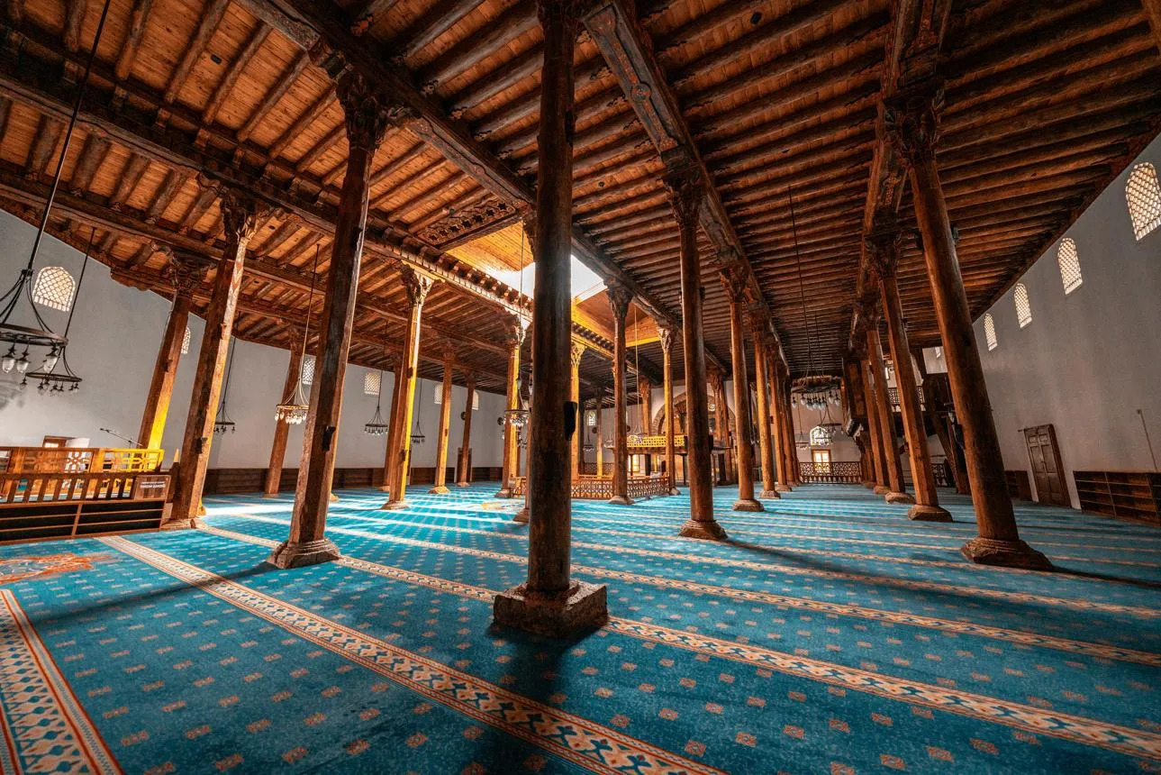 The forest of wooden columns and painted ceiling inside the Eşrefoğlu Mosque