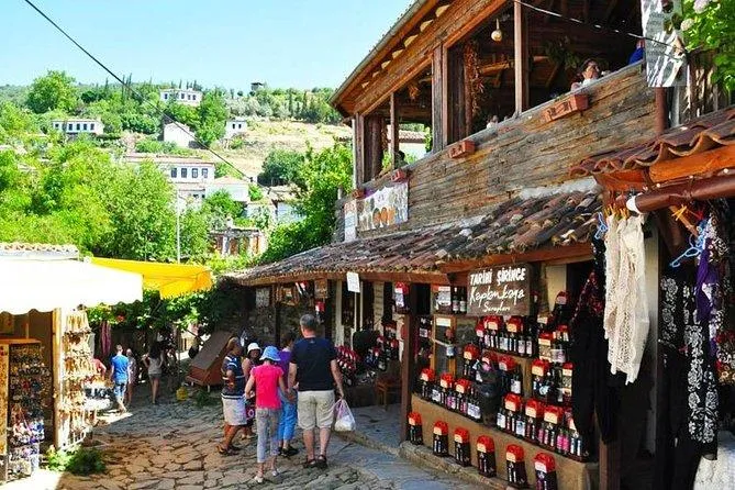 Shelves of Şirince fruit wine bottles in a wooden shop on the village street