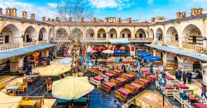 The busy arcaded courtyard of Gümrük Han filled with café tables