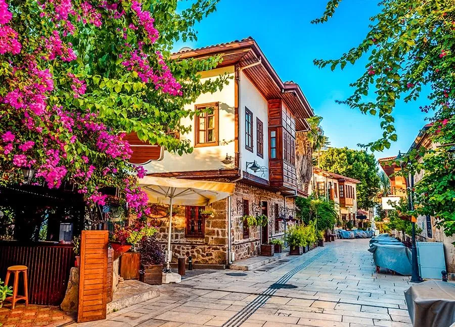 A lane in Kaleiçi lined with Ottoman houses, bougainvillea and café tables