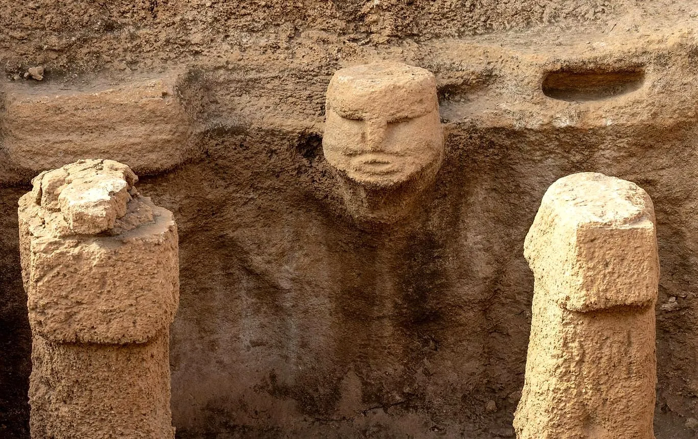 Carved human heads emerging from the rock at Karahantepe