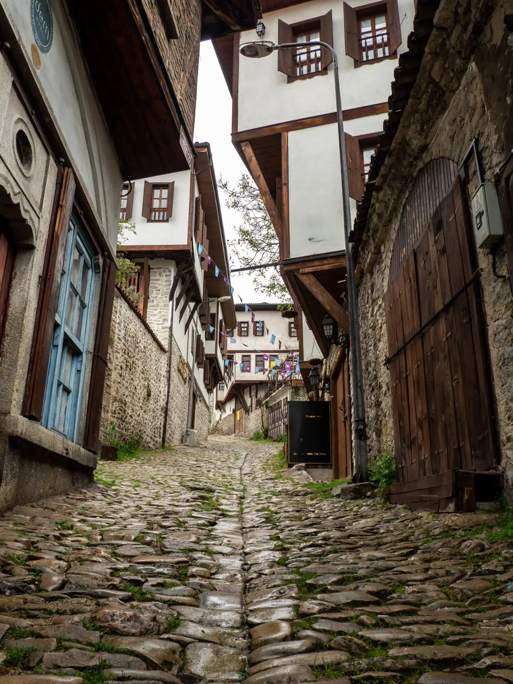 A steep cobbled lane between old timber-framed houses in Safranbolu
