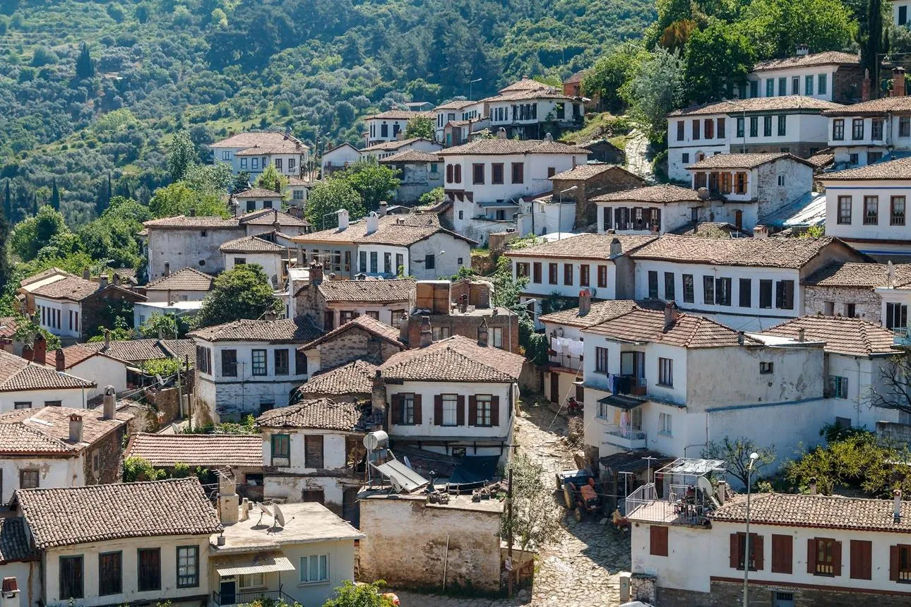The white houses of Şirince stacked on a green hillside