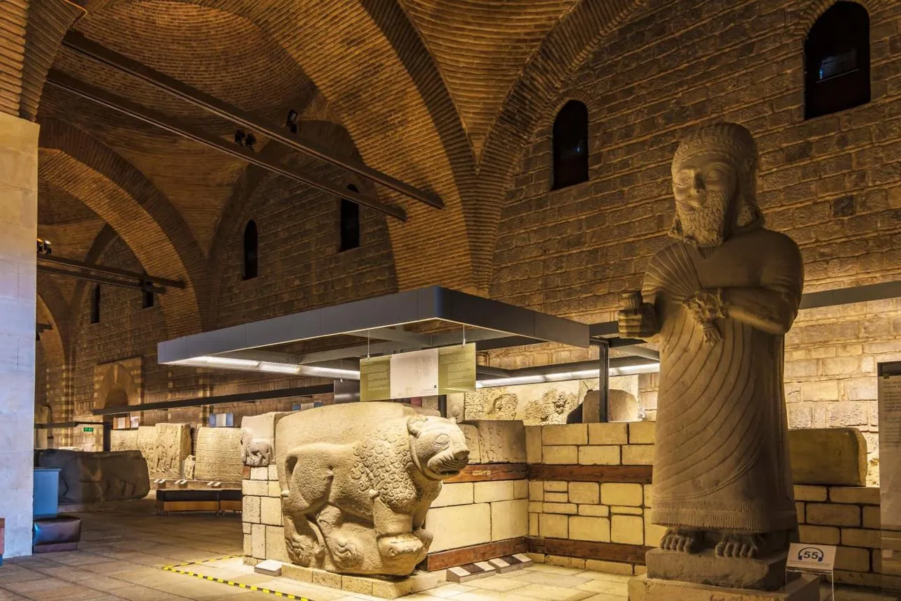 A colossal Hittite statue and stone lion in the vaulted hall of the museum