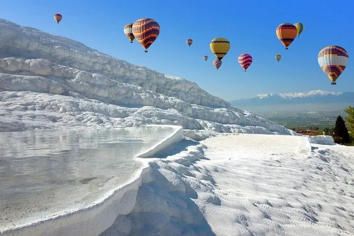 Hot air balloons above the white travertine terraces of Pamukkale