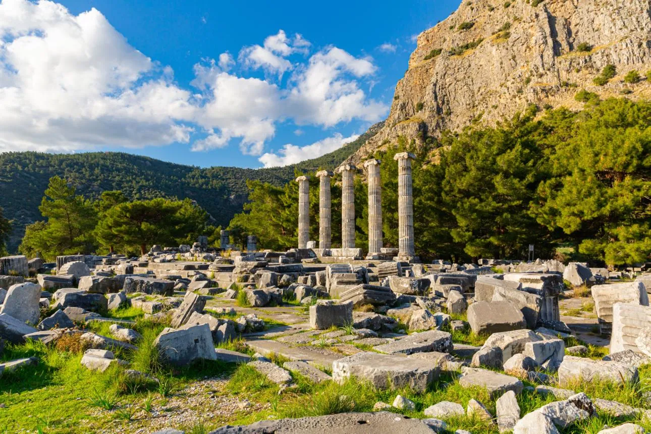 Five standing columns of the Temple of Athena at Priene below a cliff