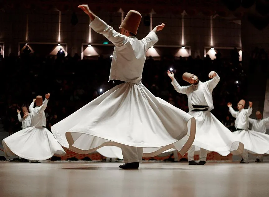 Whirling dervishes in white robes turning during a Sema ceremony
