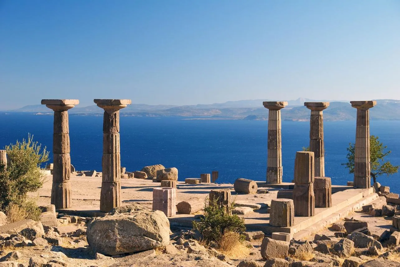 Standing Doric columns of the Temple of Athena with the blue Aegean and Lesbos behind