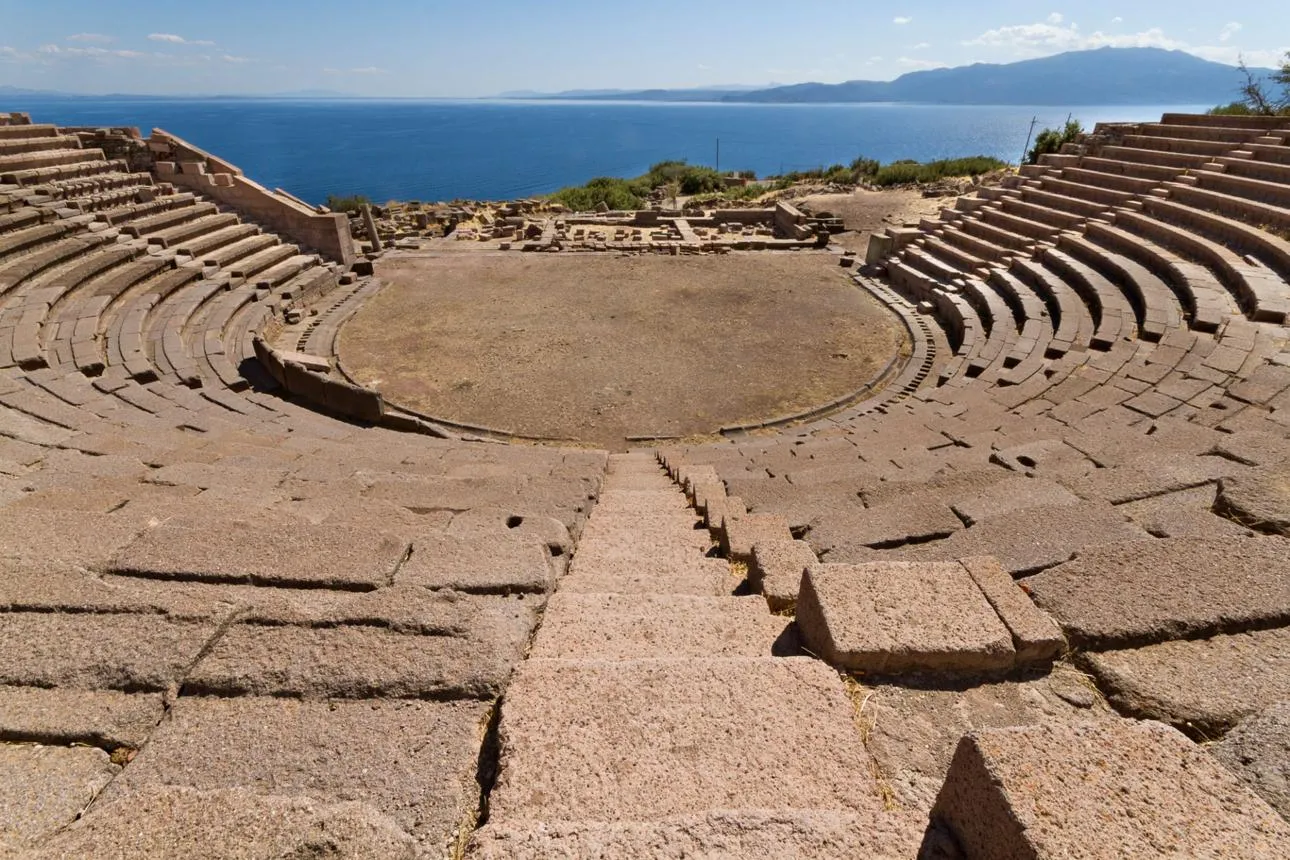 Stone seats of the ancient theatre of Assos looking out over the sea