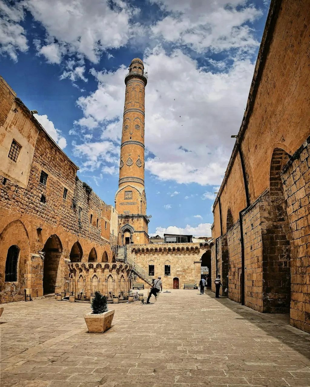 The tall minaret of Ulu Cami above a stone square in Mardin