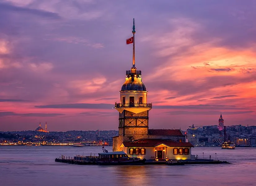 The Maiden's Tower lit up at sunset in front of the European shore